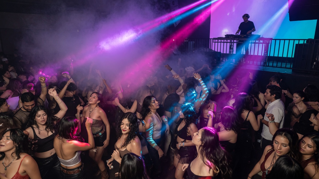 Packed dance floor under magenta and cyan lights
